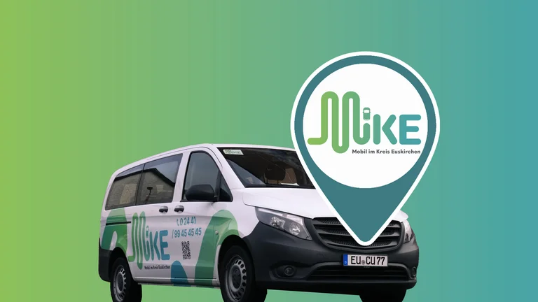 Freisteller vom Großraum-Auto für On-Demand-Verkehr mit Folierung MiKE (Mobil im Kreis Euskirchen). Darauf ein Standort-Icon mit Wort-Bild-Marke.