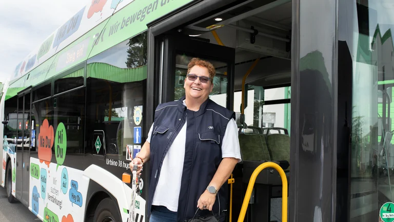 Busfahrerin steigt mit Busschlüssel aus dem Bus, ihre Schicht ist für heute beendet. So wie sie lacht, hatte sie eine Topfahrt in einem RVK Wasserstoffbus von Solaris.
