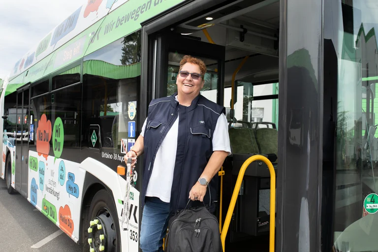Busfahrerin steigt mit Busschlüssel aus dem Bus, ihre Schicht ist für heute beendet. So wie sie lacht, hatte sie eine Topfahrt in einem RVK Wasserstoffbus von Solaris.