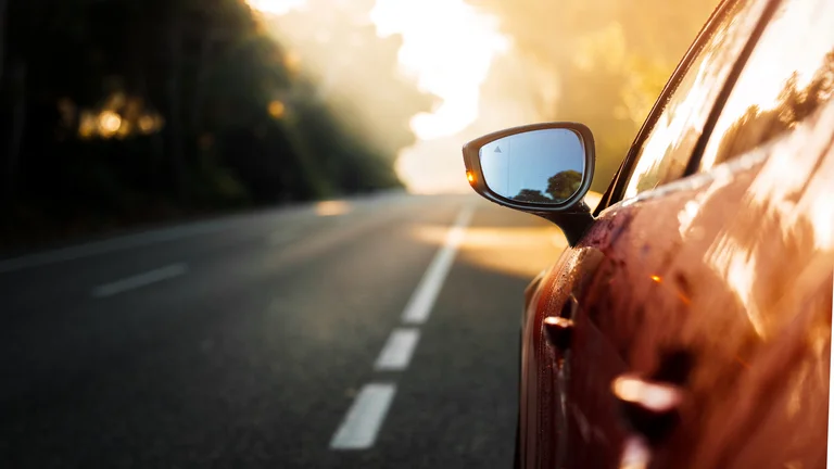 Seitenansicht eines Autos auf einer Straße im Morgengrauen