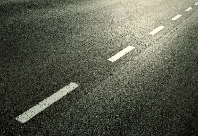 Closeup einer geteerten Straße / Fahrbahn
