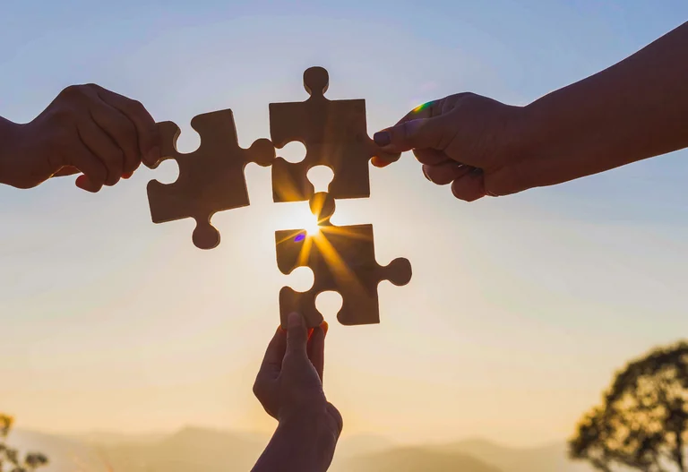 Zusammenarbeit: Hände mit Puzzleteilen, die ineinandergreifen