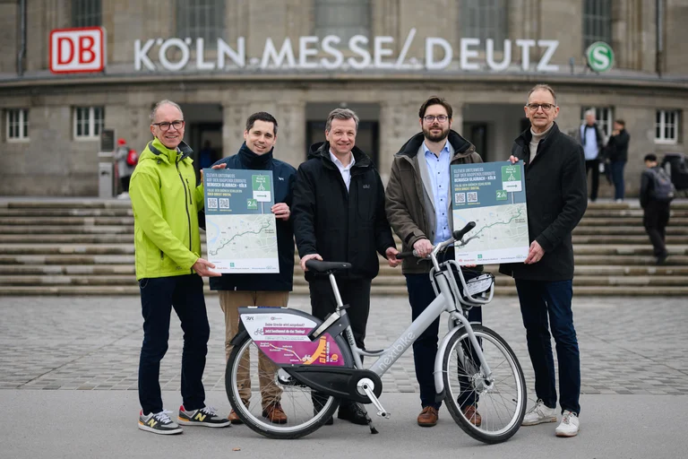 Das Bild zeigt Projektbeteiligte des S11-Bike, die ein Schild und ein Fahrrad halten
