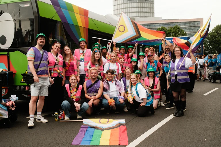 Das Bild zeigt ein Gruppenfoto von den Teilnehmenden der RVK an der CSD-Demo vor einem Bus.