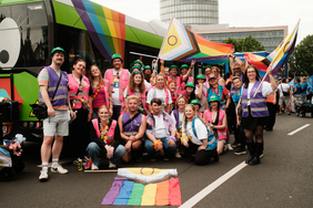 Das Bild zeigt ein Gruppenfoto von den Teilnehmenden der RVK an der CSD-Demo vor einem Bus.