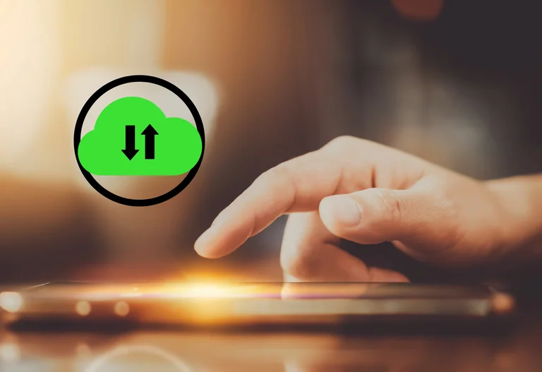 Hand auf Tastatur im Hintergrund, im Vordergrund ein Symbol aus grüner Wolke und schwarzen Pfeilen für Downloads