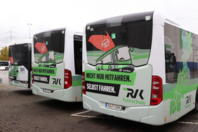 Das Bild zeigt die Hecks von drei Fahrschulbussen mit der Aufschrift "Nicht nur mitfahren. Selbst fahren."