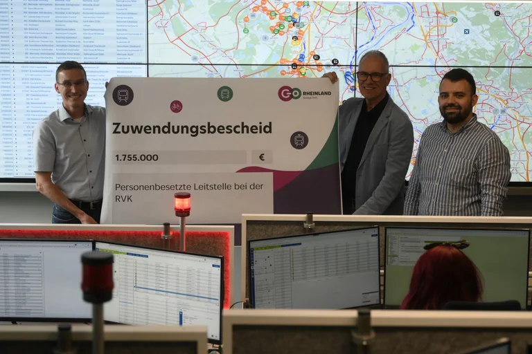 Das Bild zeigt Dr. Marcel Frank, Dr. Norbert Reinkober und Deniz Rath-Demirtas, die einen symbolischen Förderbetrag in den Händen halten