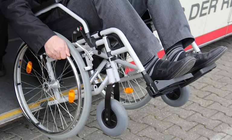 Ein Rollstuhl wird rückwärts in einen abgesenkten Bus gefahren